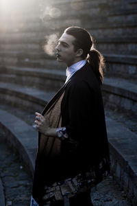 Young male model standing on steps during sunset