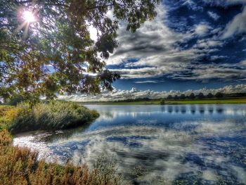 View of calm lake against cloudy sky