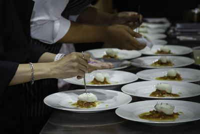 Chef cooking add some sauce to dessert dish. decorating delicious meal in restaurant hotel kitchen 