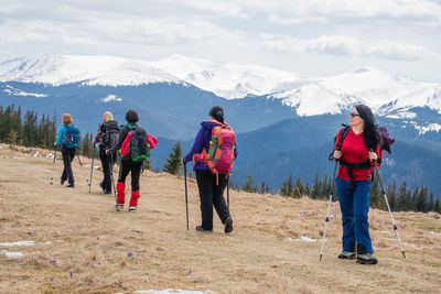 Rear view of people walking on mountain