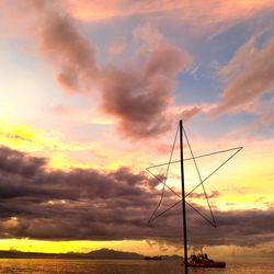 Scenic view of sea against dramatic sky during sunset