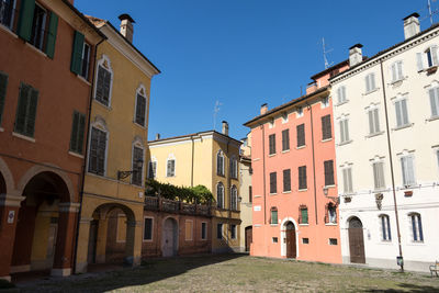 Low angle view of buildings in town against blue sky