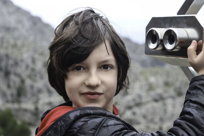 Portrait of boy holding coin operated binoculars