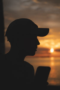 Silhouette woman standing against sky during sunset