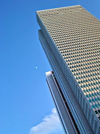 Low angle view of modern building against blue sky