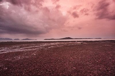 Scenic view of sea against dramatic sky during sunset