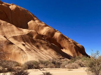 Rock formations in desert against clear blue sky