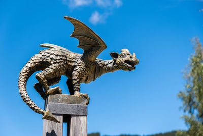 Low angle view of statue against blue sky