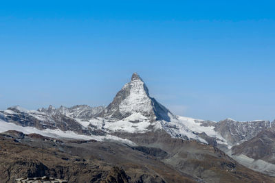 Scenic view of snowcapped mountains against clear blue sky