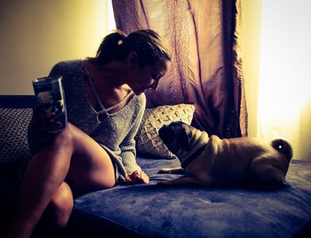 Young woman with dog sitting at home