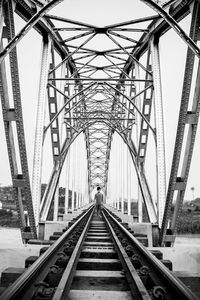 Man walking on railway bridge against sky