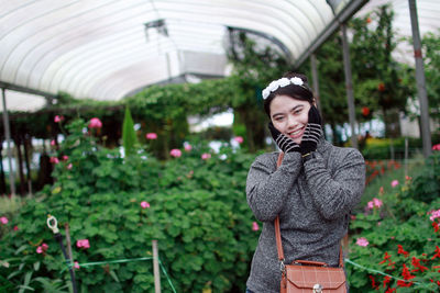 Young woman standing in greenhouse