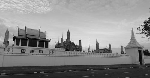 Built structure by river against sky