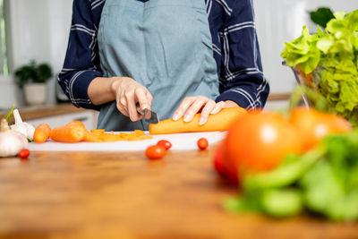 Midsection of man standing on cutting board