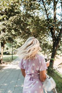 Rear view of woman walking on footpath