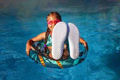 Teen in pool with upturned soles, perfect for text placement.