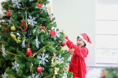 Woman standing by christmas tree