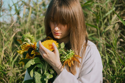 Young woman holding yellow flower