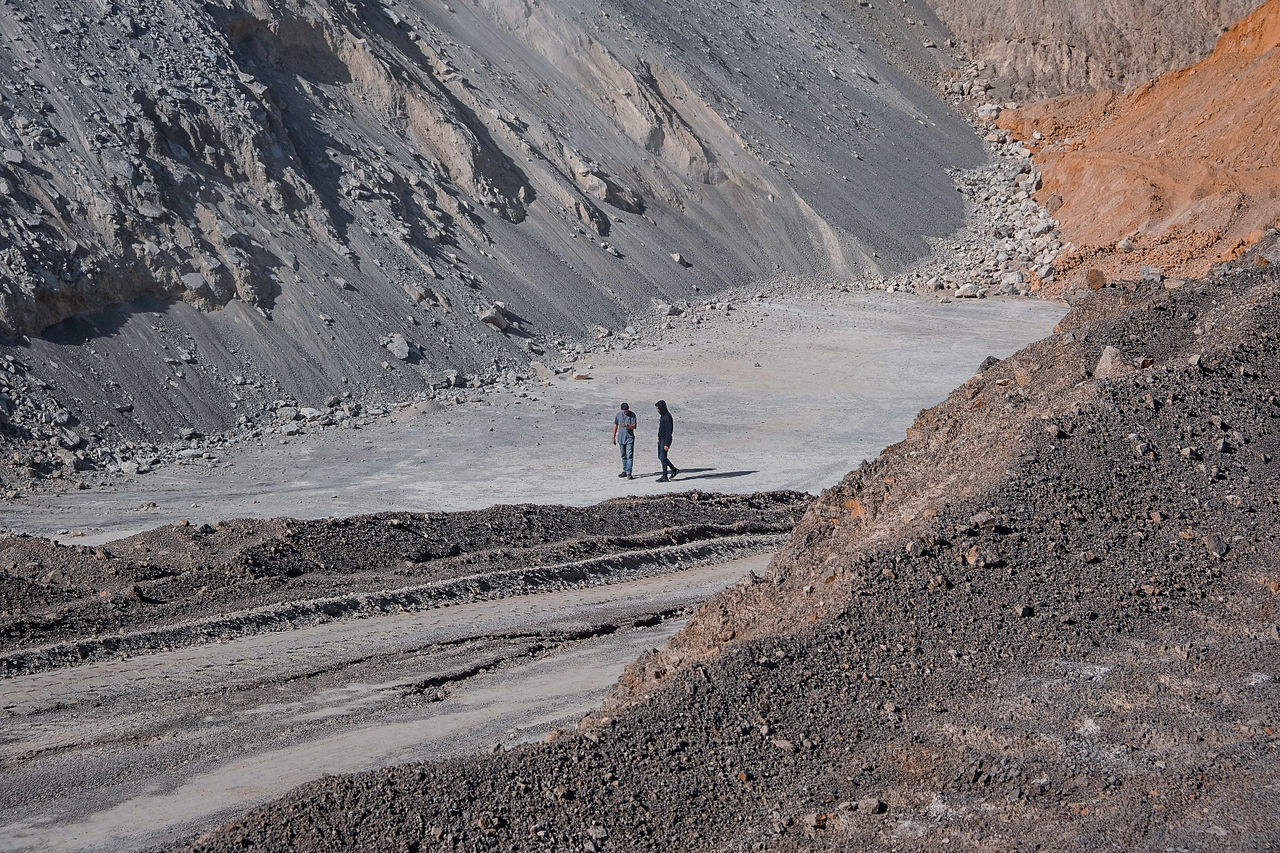 mountain, leisure activity, real people, environment, men, scenics - nature, non-urban scene, lifestyles, landscape, nature, day, beauty in nature, one person, land, walking, full length, tranquil scene, unrecognizable person, tranquility, climate, outdoors, arid climate