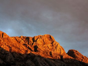 Low angle view of rocky mountains against sky