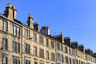 Low angle view of buildings against clear blue sky