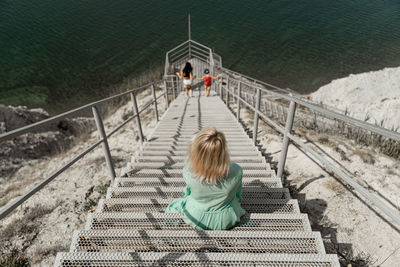 Rear view of women sitting on staircase