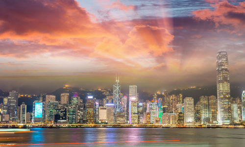 Illuminated buildings in city against sky