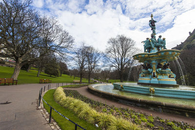 Statue by trees in park against sky