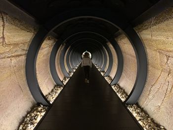 Rear view of man standing in tunnel