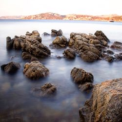 Rocks in sea against sky