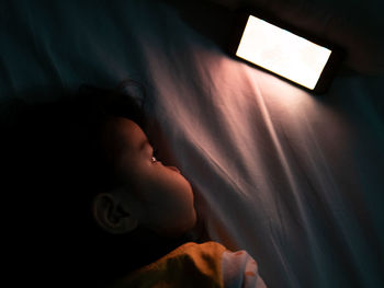 Close-up of toddler using mobile phone in dark