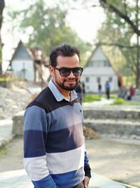 Portrait of smiling young man standing on walkway