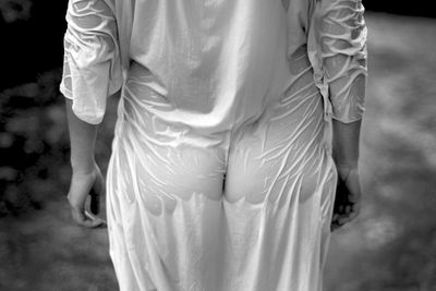 Rear view of man with wet clothes standing outdoors