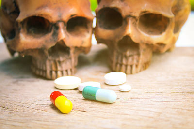 Close-up of human skull and pills on table