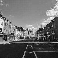 Surface level of road by buildings against sky