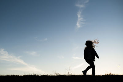 Silhouetted girl playing running on hill in waco texas