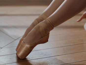 Low section of woman standing on hardwood floor