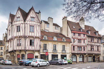 Cars on street by buildings against sky