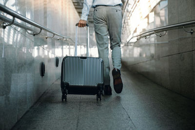 Low section of man walking at airport