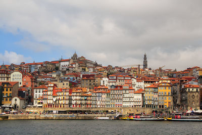 River by buildings in town against sky