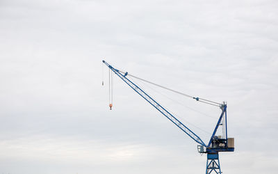 Low angle view of crane against sky