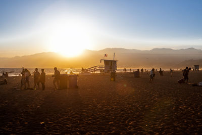 People at beach during sunset
