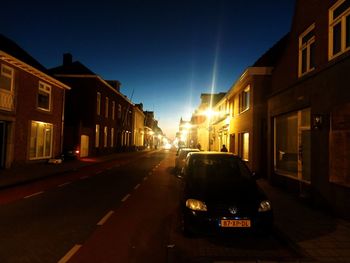 Cars on street amidst buildings in city at night