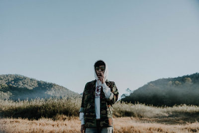 Man standing on field against clear sky