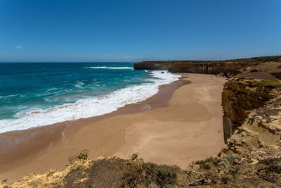 Scenic view of beach against blue sky