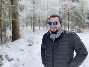 Portrait of smiling man standing in snow