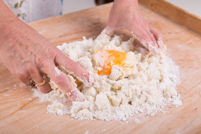 Close-up of hand holding bread on cutting board