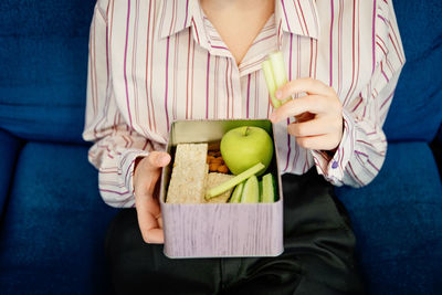 Healthy snack for office worker. woman hands with lunch box at workplace