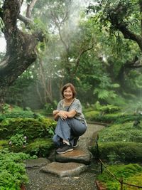 Portrait of woman sitting in forest