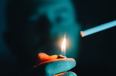 Close-up of hand holding lit candle